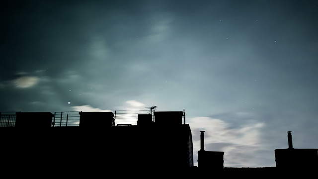 Moon and clouds behind house fronts